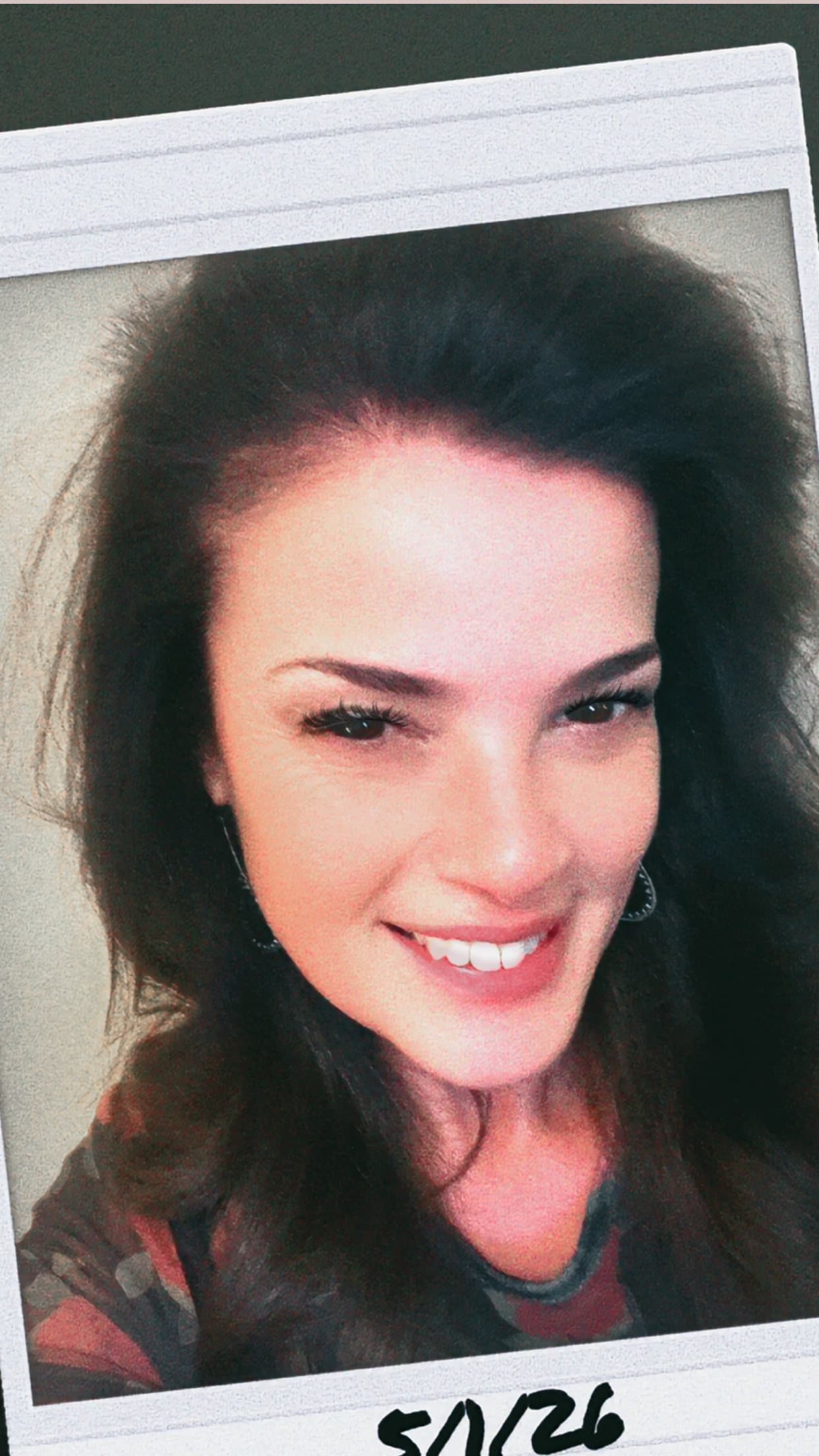 Smiling woman with dark hair in a white Polaroid-style frame with a handwritten date.